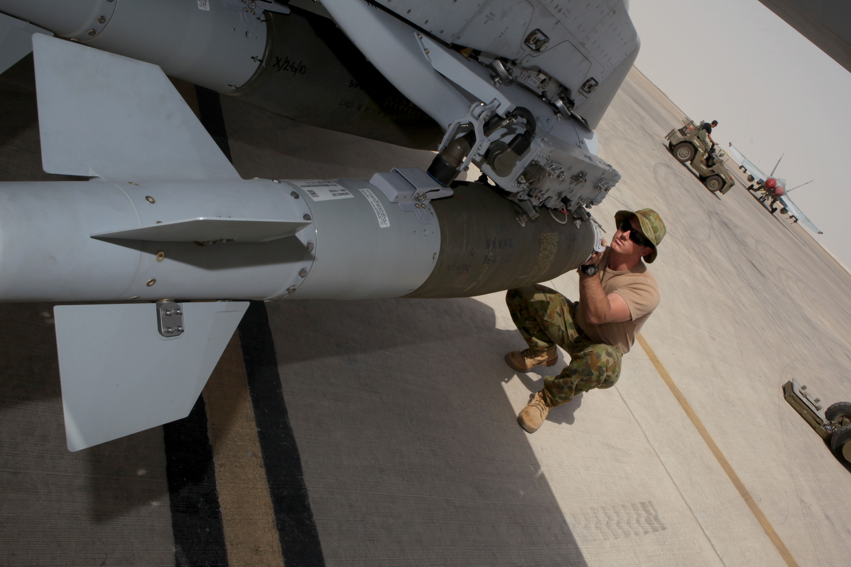 Ayustralian Armament Technician performs final checks after loading a GBU-38 weapon on an F/A-18A Hornet in the Middle East (Australian MoD)