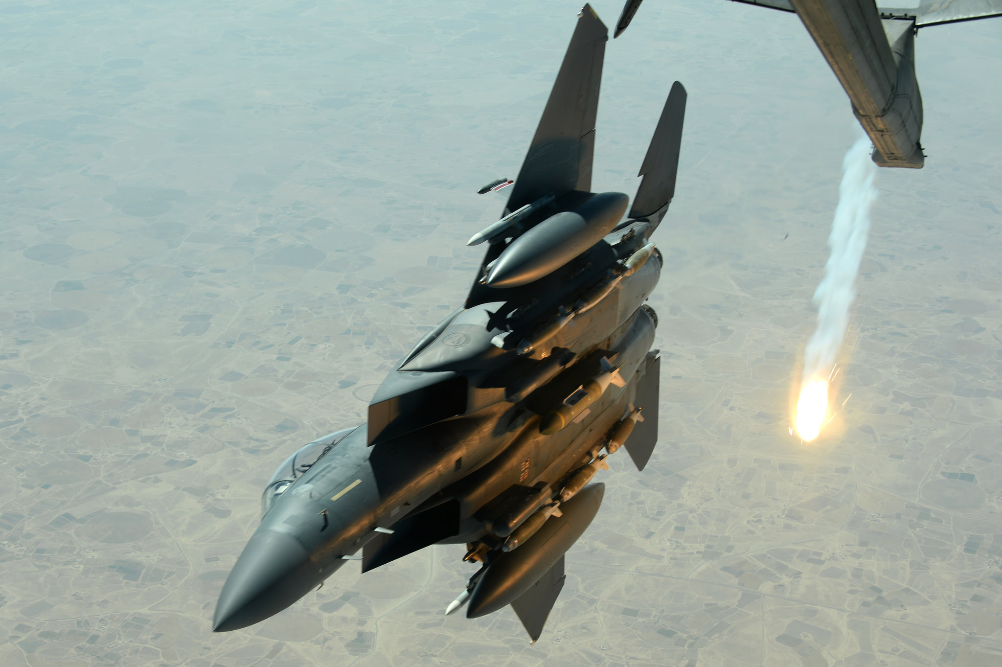 A U.S. Air Force F-15E Strike Eagle pops a flare while departing after refueling with a USAF KC-10 Extender aircraft over Southwest Asia in support of Operation Inherent Resolve, Aug. 30, 2015. U.S. Air Force photo by Staff Sgt. Sandra Welch