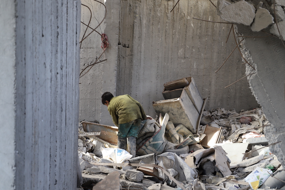 Mohammad, a survivor searches through the rubble two years on from the airstrike which killed his entire family. (via Amnesty)