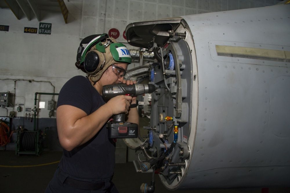 Maintenance is performed on an F/A-18F Super Hornet assigned to the Fighting Swordsmen of Strike Fighter Squadron (VFA) 32 in the hangar bay of the aircraft carrier USS Dwight D. Eisenhower (US Navy)