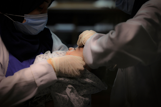 Image of baby Omar Al Hadidi, pulled from the rubble in critical condition and bring treated in a hospital following strikes on Al Shati camp on May 15th, 2021. (Image posted by @alqudsnewspaper)