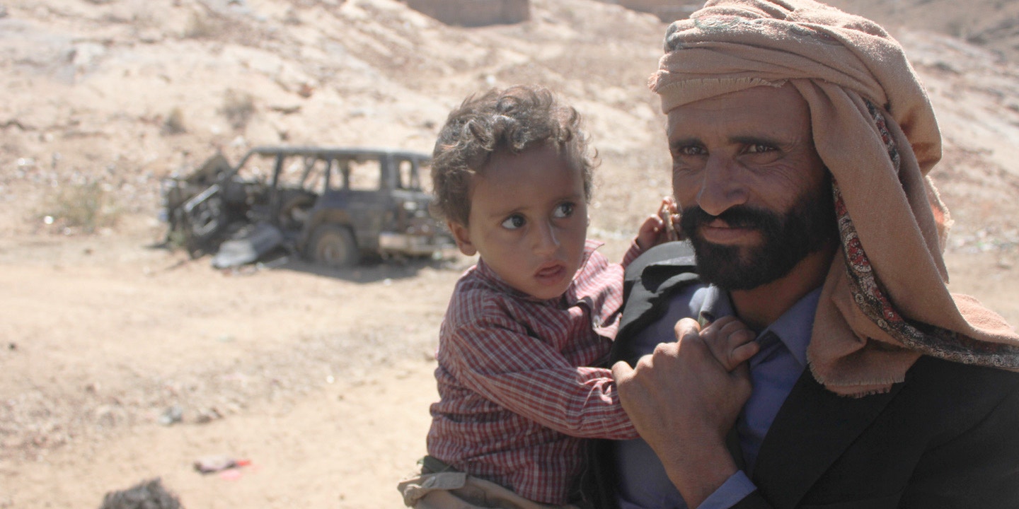 "Mabkhout Ali al Ameri stands with his 18-month-old son, Mohammed, in the village of al Ghayil in Yemen’s al Bayda province. Mabkhout’s wife, Fatim Saleh Mohsen, was shot in the back of the head by helicopter gunship fire as she fled with Mohammed in her arms during a U.S. raid on January 29, 2017. The vehicle in the background was also destroyed during the assault." (The Intercept, March 9th 2017)