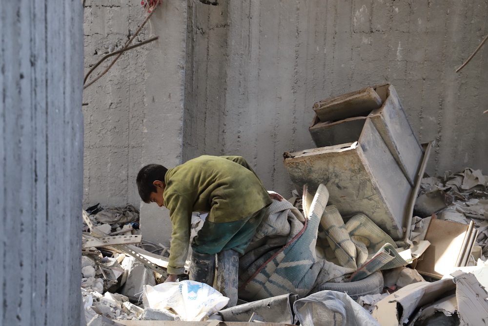 Mohammad, a survivor searches through the rubble two years on from the airstrike which killed his entire family. (via Amnesty)