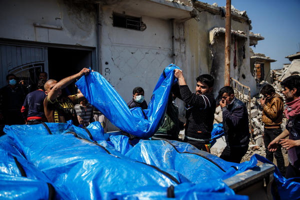 Body bags being carried away after the strike (via LA Times)