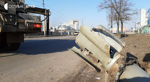 Image showing what looks to be a rocket embedded in the road following Russian shelling of Kharkiv on March 24, 2022. (Image posted by @eoin_mc_sweeney)