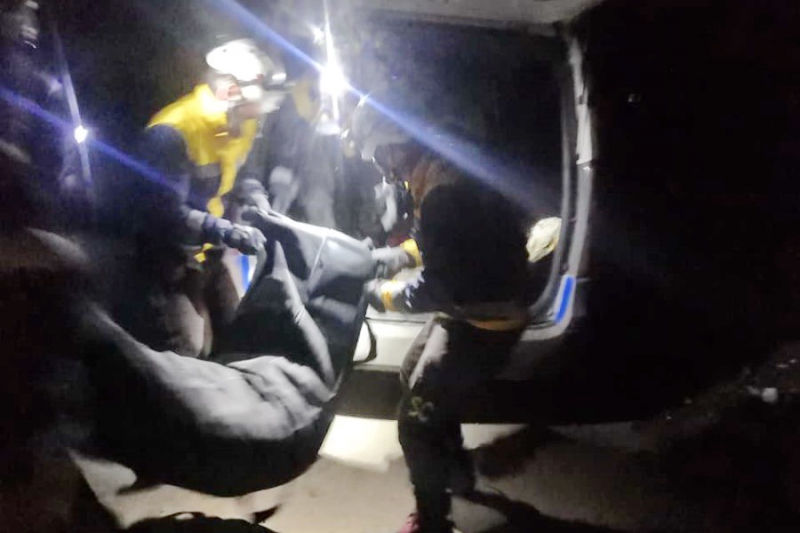 Syrian Civil Defence volunteers carrying a body after alleged Russian airstrikes on the village of Arinba on January 23rd, 2020 (via SCD).