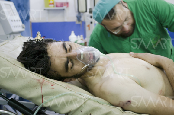 A civilian is treated by a medic after sustaining injuries in alleged Russian airstrikes (via Smart)