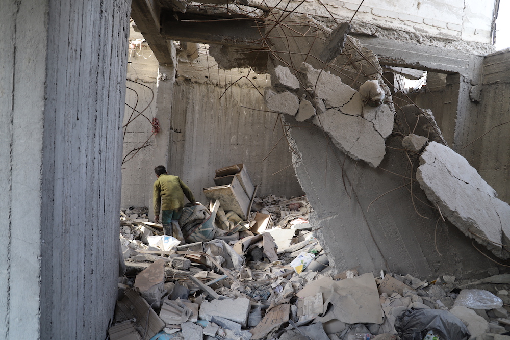 Mohammad, a survivor searches through the rubble two years on from the airstrike which killed his entire family. (via Amnesty)