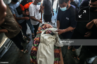 Body of the child identified as Ibrahim Al-Rantissi who was killed in strikes on Al Jeniya neighborhood on May 13, 2021. (Image posted by Getty)