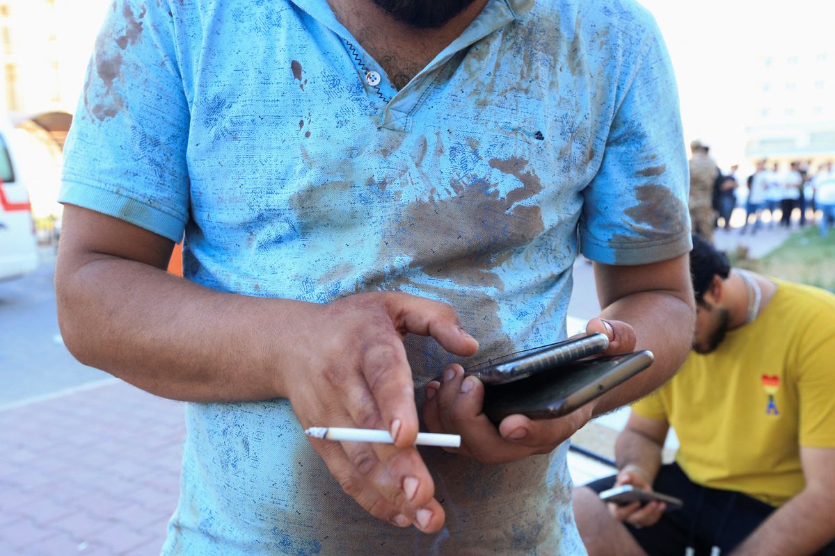 A man stands outside a hospital with a blood-stained shirt after a Turkish attack, in Zakho, Iraq, July 20, 2022. REUTERS/Ari Jalal.