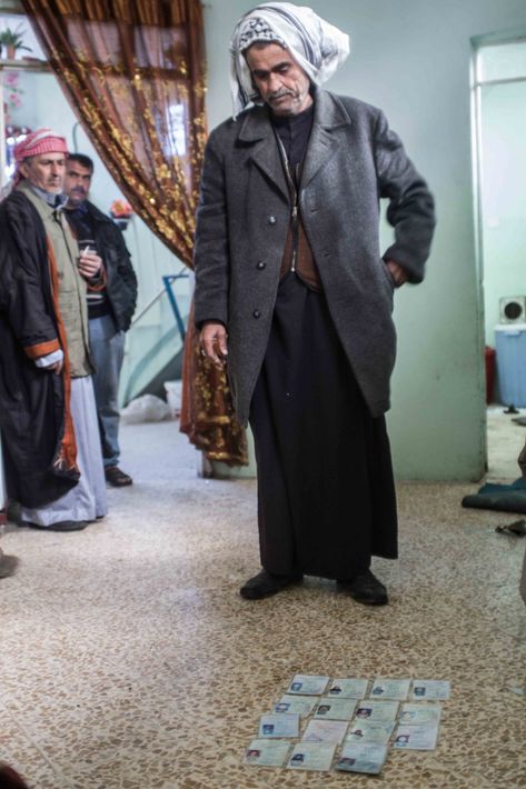 Khalef Khudair, 50, shows the IDs of relatives killed in an airstrike in Mahatta, on the 14 of March 2017 © Jérémy André