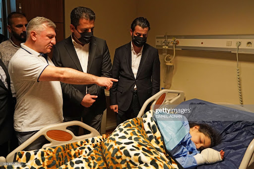 Saman Barzanji (C), Health Minister of Iraq's autonomous Kurdistan Region, visits the victims injured by Turkish shelling at a hospital in the city of Zakho in the north of Iraq's autonomous Kurdish region on July 20, 2022. - Nine civilians including children were killed in a park in Iraq's autonomous Kurdistan region by artillery fire that Baghdad blamed on neighbouring Turkey, a country engaged in a cross-border offensive. (Photo by Ismael ADNAN / AFP) (Photo by ISMAEL ADNAN/AFP via Getty Images)