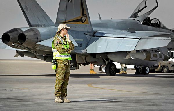 RAAF Chaplain, Flight Lieutenant Robyn Kidd, on the tarmac at Australia's main air operating base in the Middle East region, in front of a RAAF F/A-18A Hornet Fighter aircraft. (Aus MoD)