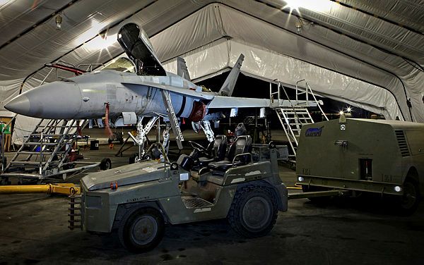 A RAAF F/A-18A fighter aircraft aircraft sits inside a hangar in preparation for routine deeper level maintenance at Australia's main air operating base in the Middle East region.
