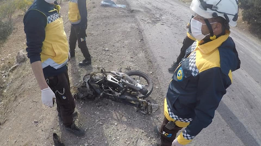 White Helmets observe the motorcycle struck with a drone attack on the Ariha Al-Mastouma road on December 3, 2021. (Image posted by Syrian Civil Defense)