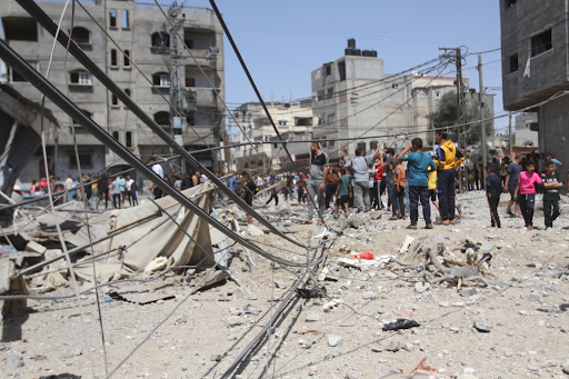 People stand in the rubble of a house reportedly destroyed by an Israeli airstrike May 20 2021 in Shaboura, Gaza. Image posted on Twitter by @Alaqsavoice_Brk.