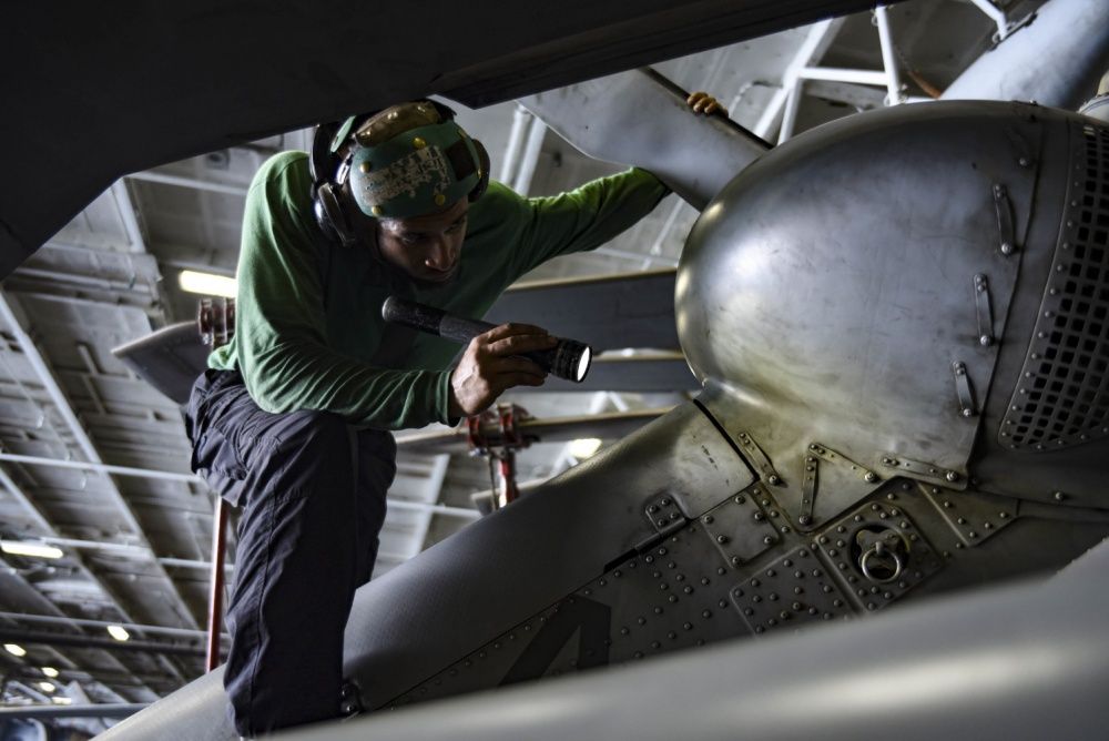 A corrosion inspection is carried out on a MH-60S Sea Hawk helicopter assigned to the Dusty Dogs of Helicopter Sea Combat Squadron (HSC) 7 in the hangar bay of the aircraft carrier USS Dwight D. Eisenhower, Oct 11th (US Navy) 
