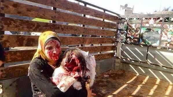 Reported survivor of a coalition airstrike in Syria holds the body of a child, June 25 2015
