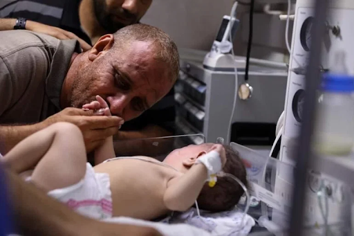 Father of baby Omar reunited with his child after his whole family is killed in Israeli strikes on Al Shati camp on May 15th, 2021. (Image posted by Al Jazeera)