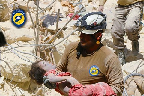 A member of the White Helmets rescues a child from the rubble following an airstrike on Al Kalassa, April 28th (via White Helmets)