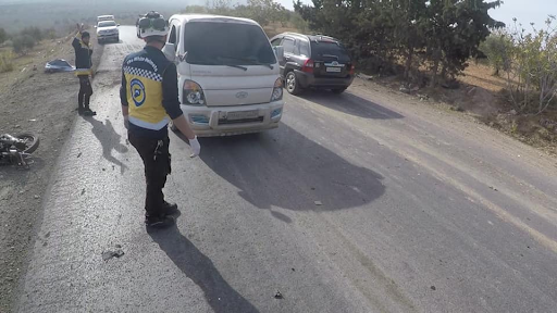 White Helmets observe the car struck with a drone attack on the Ariha Al-Mastouma road on December 3, 2021. (Image posted by Syrian Civil Defense)