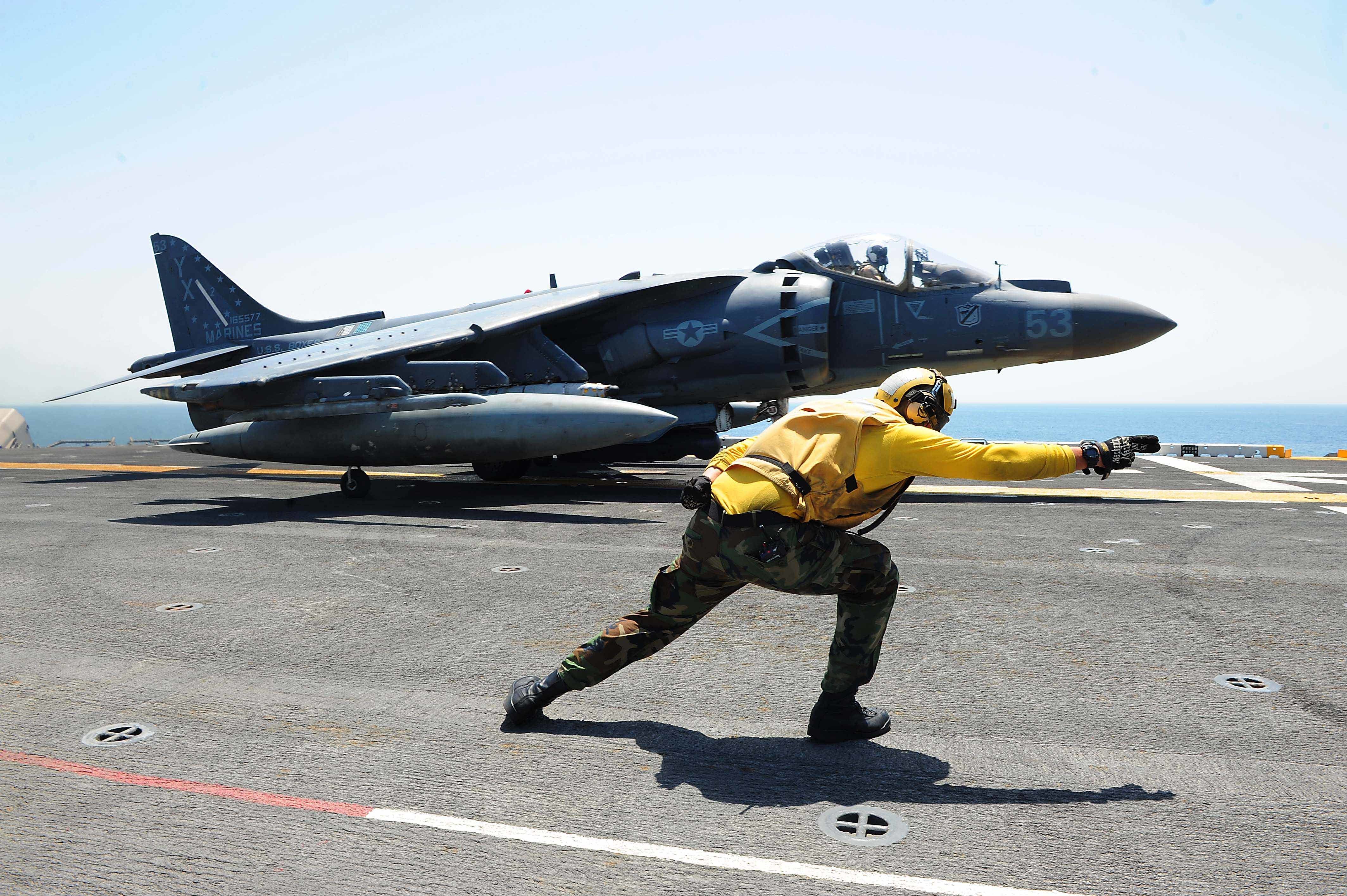 160711-N-VD165-166 ARABIAN GULF (July 11, 2016) Aviation Boatswain’s Mate (Handling) 3rd Class Chase Coker launches an AV-8B Harrier II, attached to 13th Marine Expeditionary Unit (MEU), off the flight deck of amphibious assault ship USS Boxer (LHD 4). Boxer is the flagship for the Boxer Amphibious Ready Group and, with the embarked 13th MEU, is deployed in support of Operation Inherent Resolve, maritime security operations and theater cooperation efforts in the U.S. 5th Fleet area of operations. (U. S. Navy photo by Mass Communication Specialist 2nd Class Jose Jaen/Released)