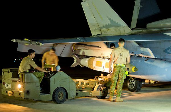 Air Task Group Strike Element Armament Technicians load ordnance on to an F/A-18A Hornet on the flight line of Australia's main air operating base in the Middle East region. [Aus DoD]