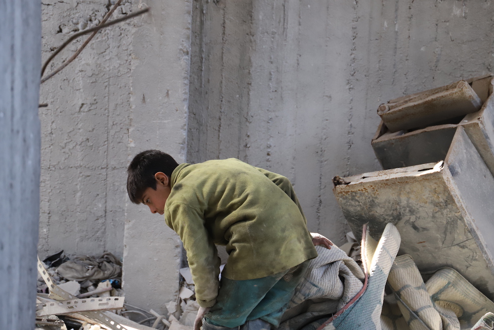 Mohammad, a survivor searches through the rubble two years on from the airstrike which killed his entire family. (via Amnesty)