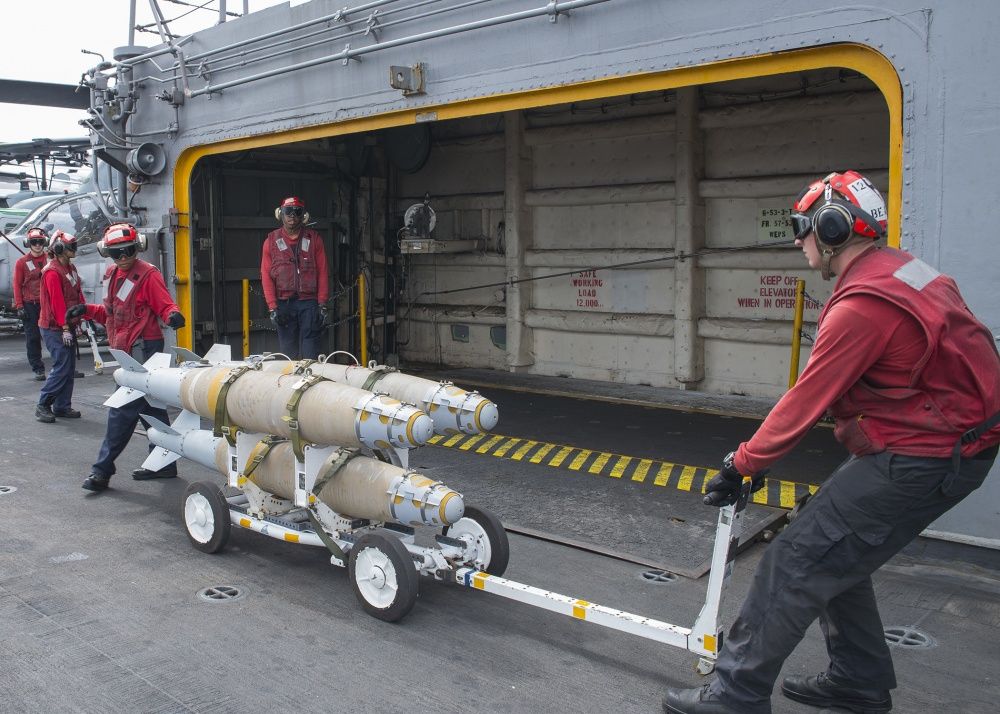Sailors move GBU-54 laser joint direct attack munition bombs onto an elevator aboard USS Wasp, Oct 6th (US Navy)