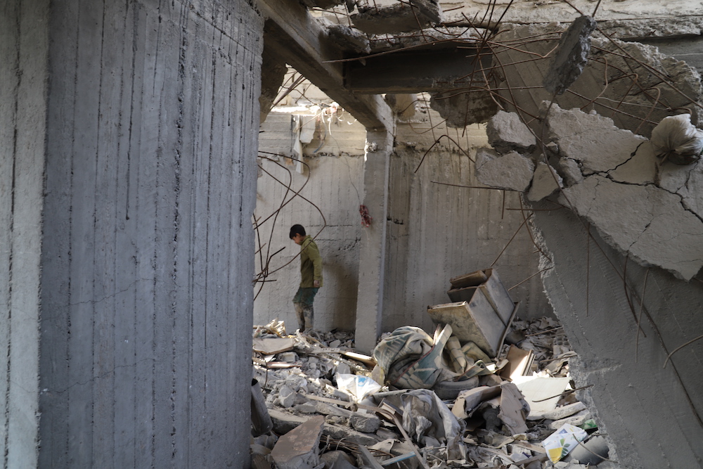 Mohammad, a survivor searches through the rubble two years on from the airstrike which killed his entire family. (via Amnesty)