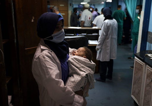 Image of baby Omar Al Hadidi, pulled from the rubble in critical condition and bring treated in a hospital following strikes on Al Shati camp on May 15th, 2021. (Image posted by @alqudsnewspaper)