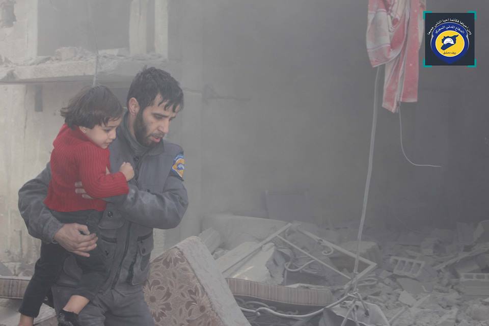 A member of the White Helmets rescues a child following an airstrike on Dayr al Asafeer , Jan 12th (via White Helmets)